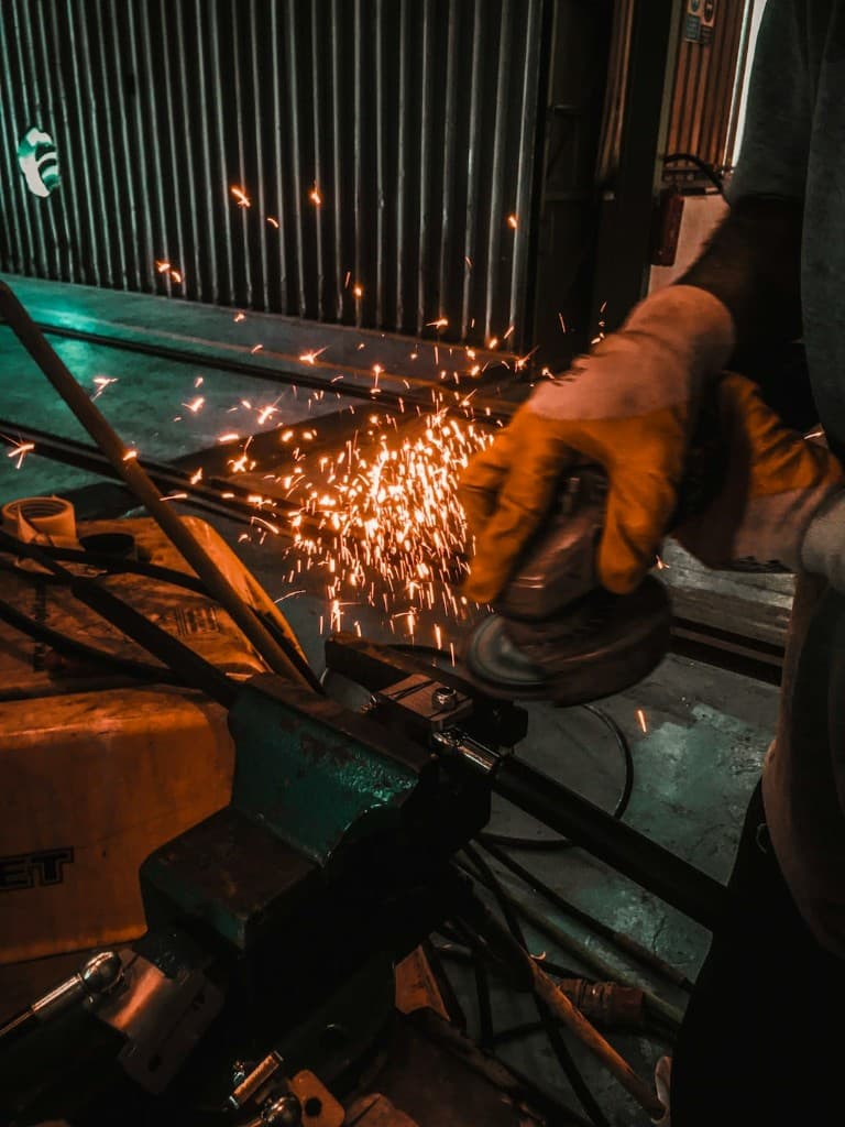 Obróbka metalu na imadle — iskry przy szlifowaniu detalu